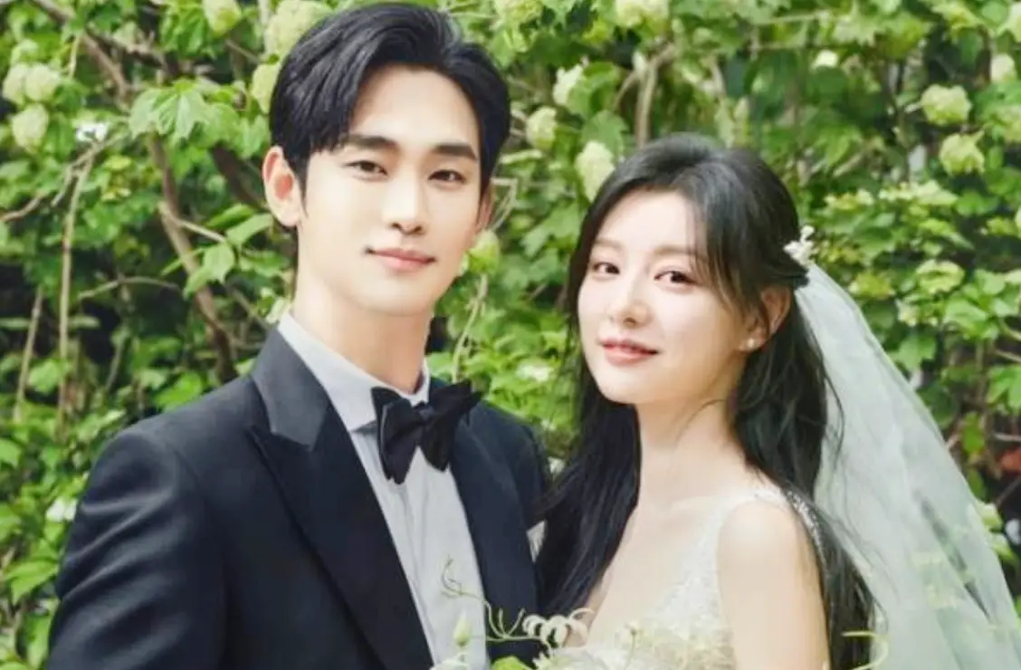 김수현-
수풀 앞 검은 턱시도 김수현과 웨딩드레스 김지원이 미소지으며 정면을 바라보는 모습
