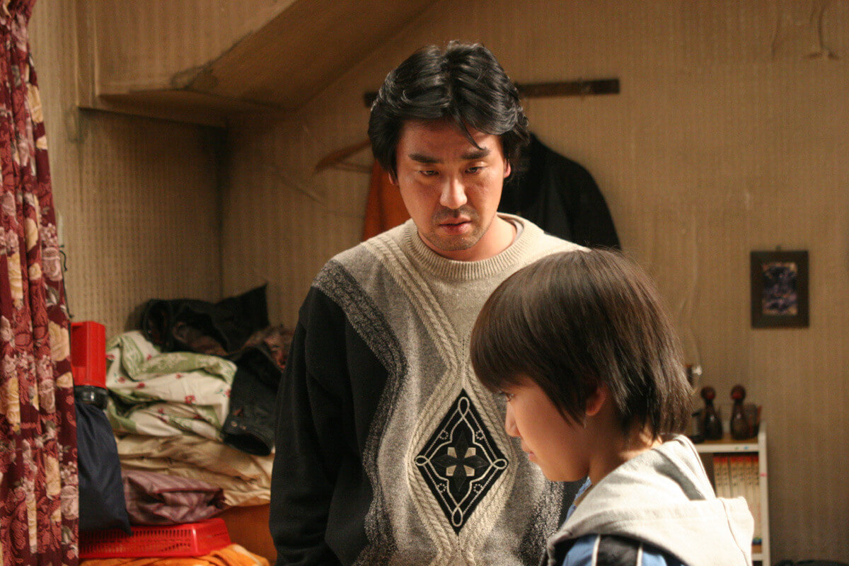 폭력적인 아버지가 재수에게 돋을 받아내려 하고 있는 모습