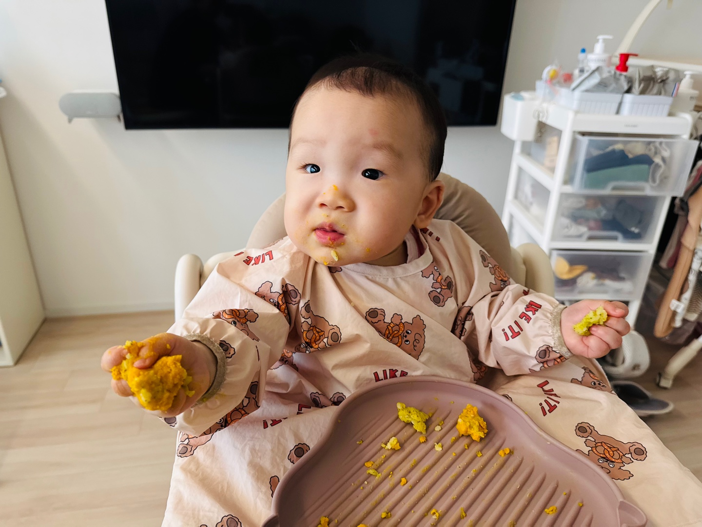 스틱 음식을 손에 쥐고 한입 가득 먹으며 엄마를 바라보는 찬솔이
