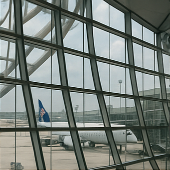 태국 국제공항의 출국장 표지판&amp;#44; 유리창 너머 항공기&amp;#44; 공항 외부의 현대적 건축 구조가 보이는 장면