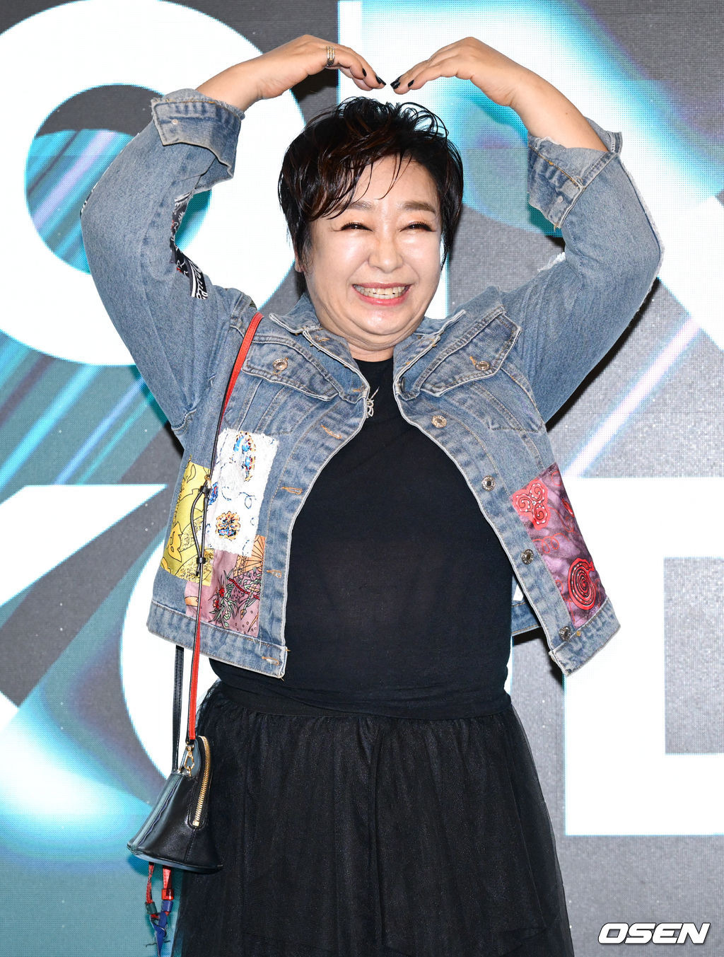 혜은이가 행사장에서 머리 위로 하트 모양을 만드는 모습