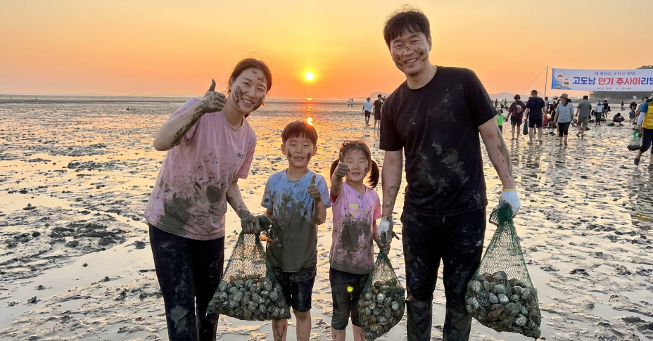 고창갯벌축제를 즐기고 돌아가는 길, 양손 무겁게 바지락을 들고 엄지 척을 하는 가족