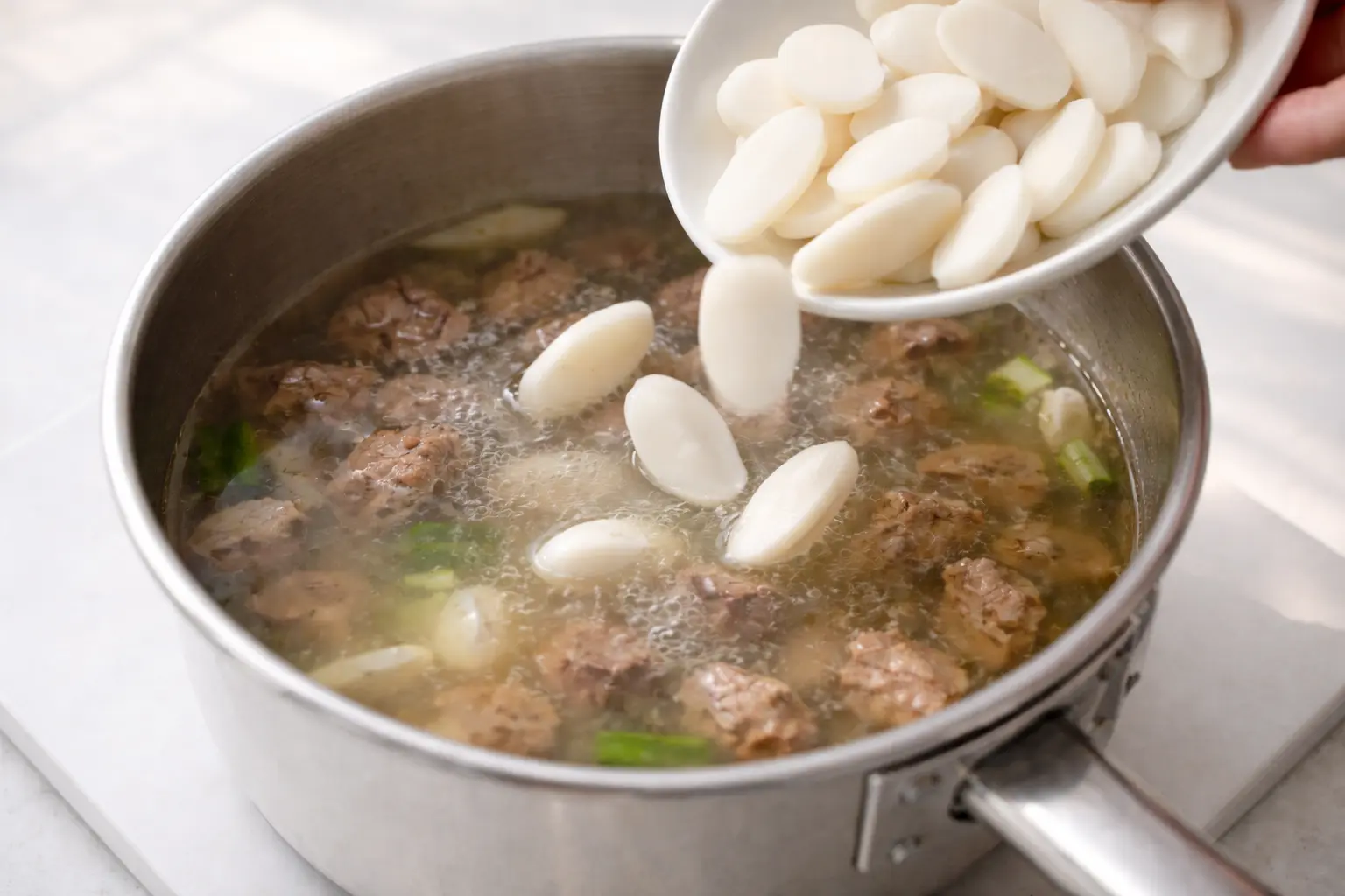 맑은 육수에 떡국떡을 넣고 끓이는 과정