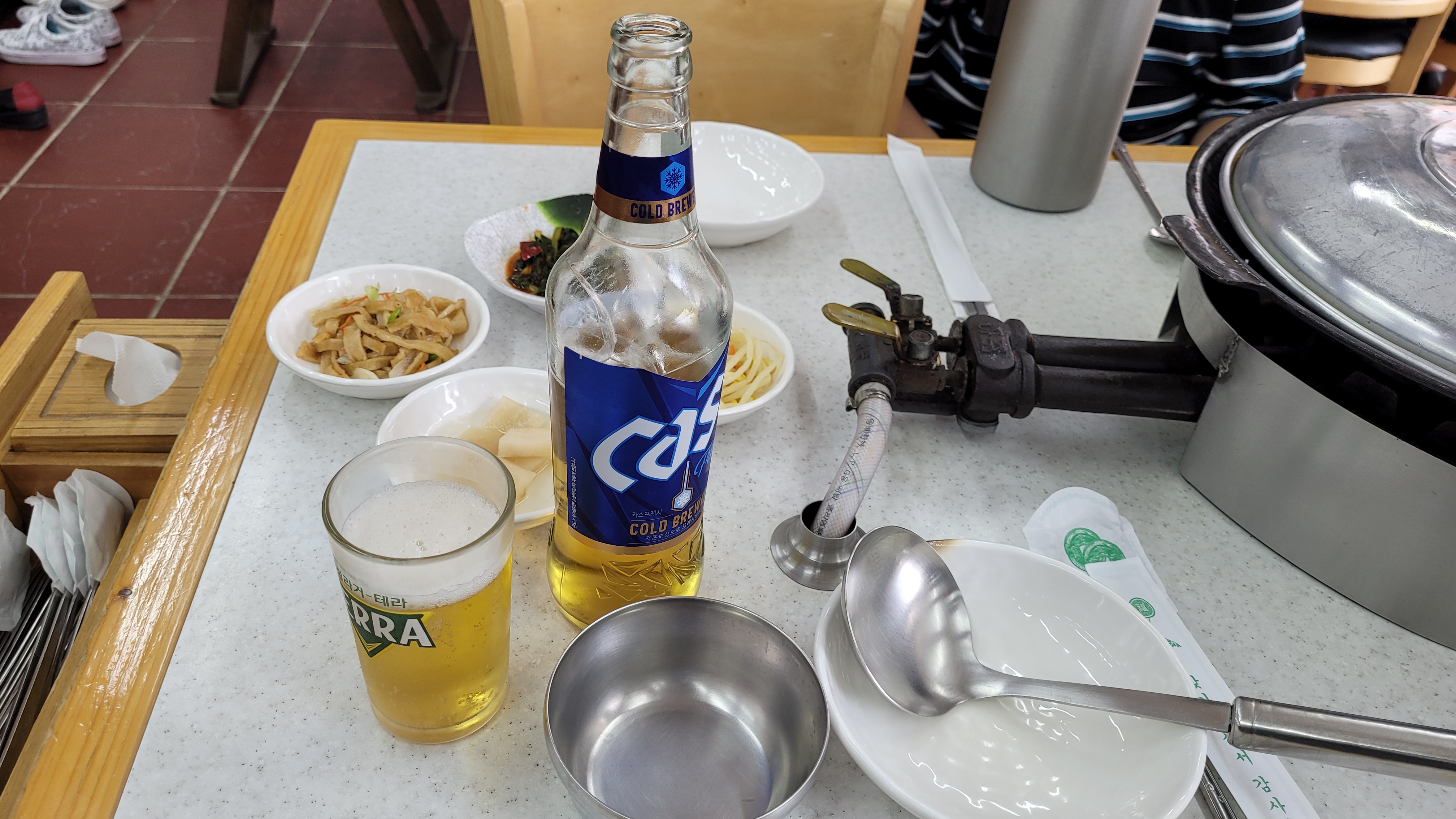 Cass 한병과 맥주잔이 테이블에 있는 모습