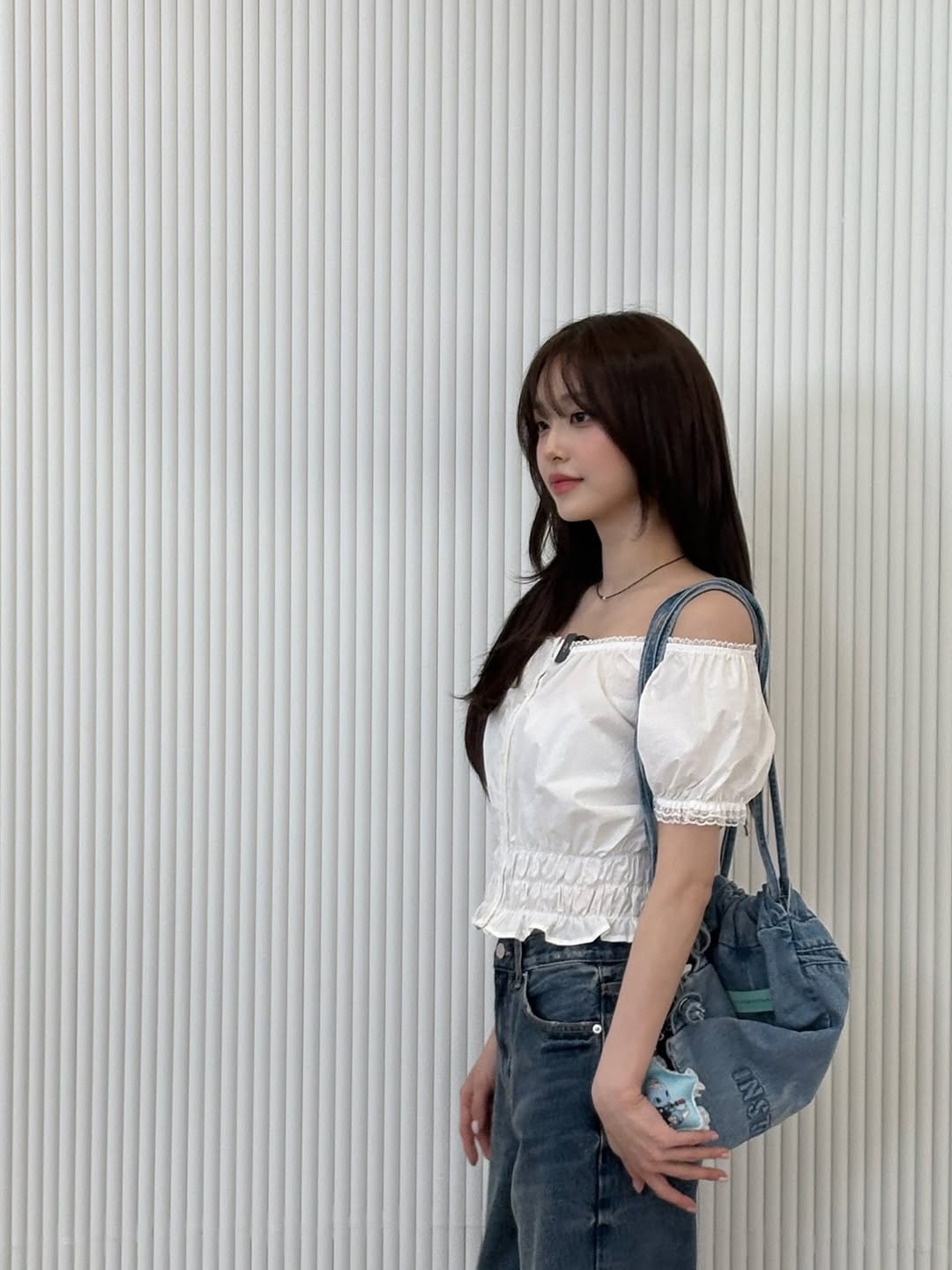 청색 에코백에 키링을 달고 서 있는 츄
