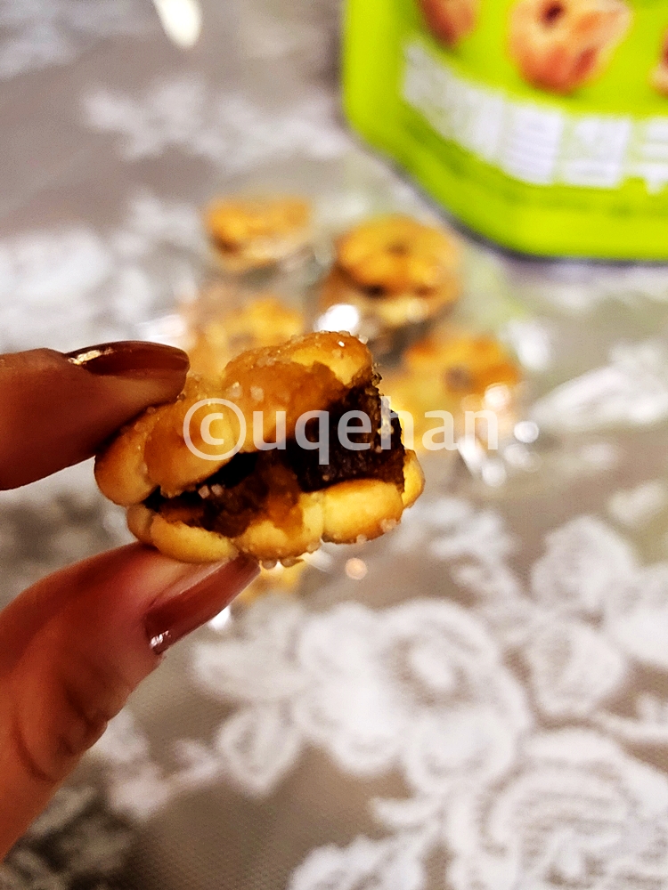 노브랜드 파인애플잼쿠키를 손으로 집고 있다. 쿠키 과자 사이에 잼이 도톰히 들어가있다.