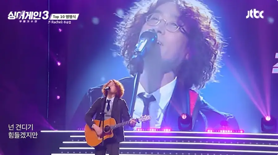 싱어게인3-
노란파마머리 금테안경 검은쟈켓, 넥타이 회색 조기, 통기타를 치며 스탠딩마이크에 노래한 59호