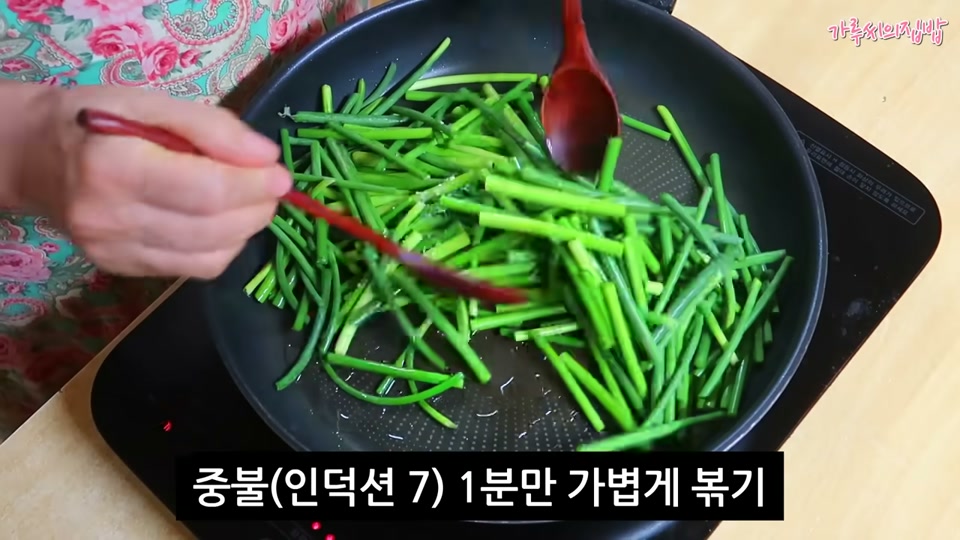 마늘종을 소금과 함께 볶는 장면