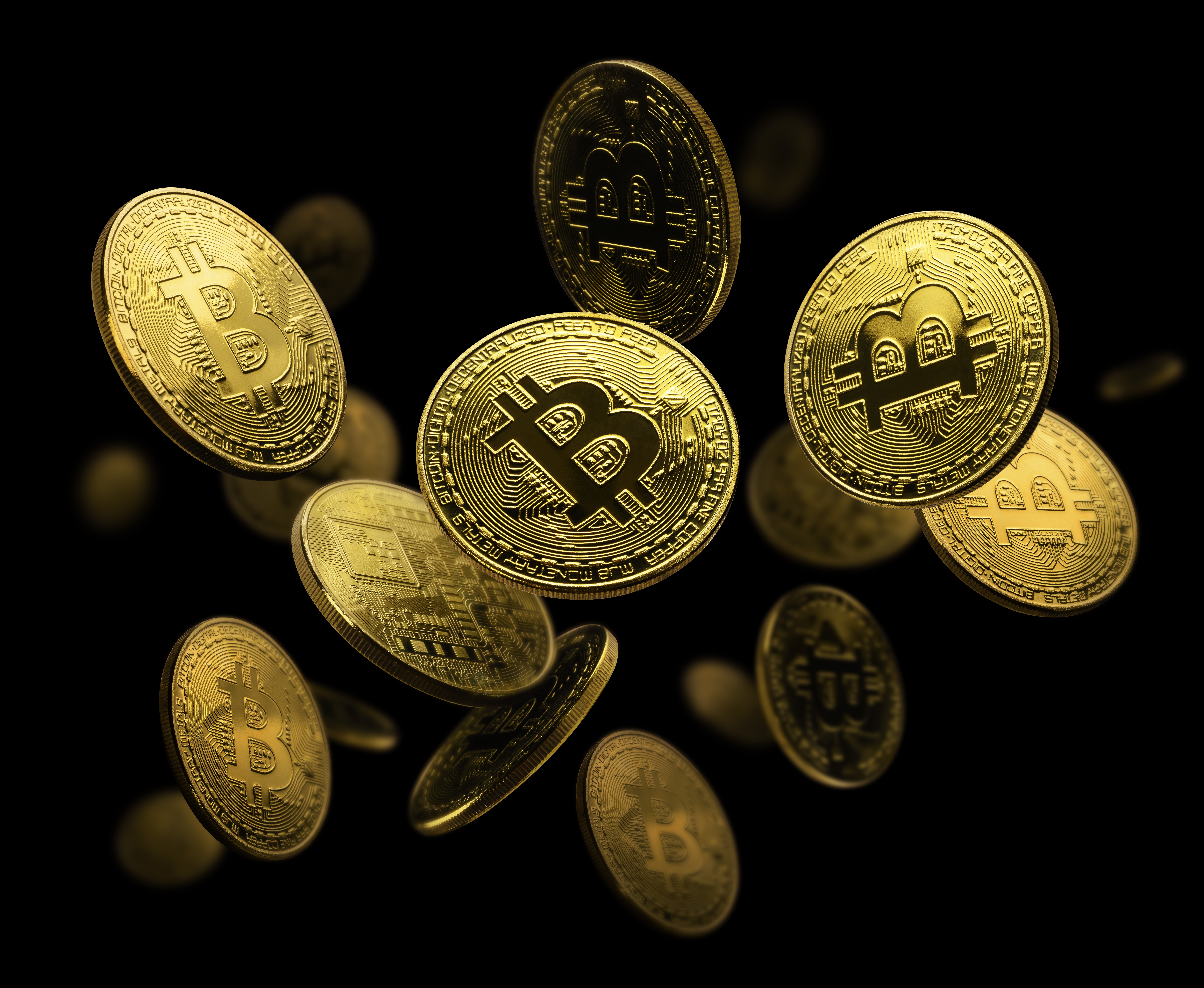 검은 배경에서 다수의 비트코인 동전이 공중에 흩날리는 장면, 비트코인 시세 변동성과 가상화폐 투자 이미지를 표현