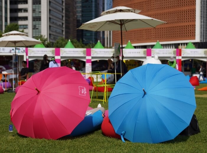 서울광장에 양산을 쓰고 앉아있는 사람들