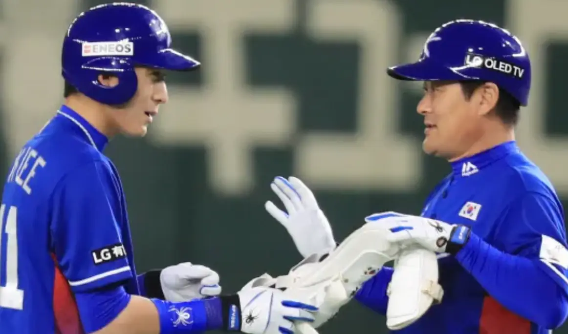 이정후-좌측 파란유니폼 파란모자를 쓴 이정후와 우측 파란유니폼 파란모자를 쓰고 이종범이 서로를 바라보고 있는 모습