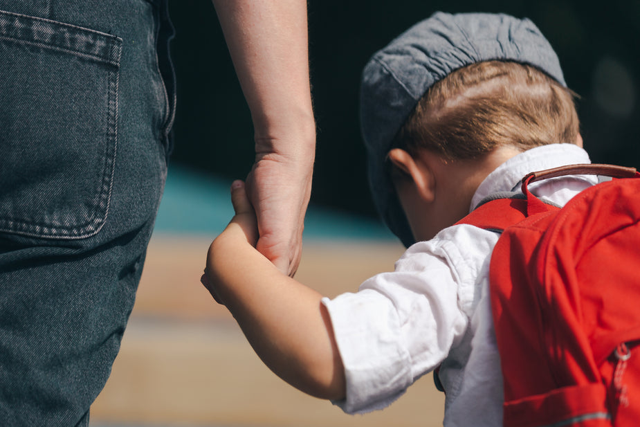 little boy holding mom's hand
