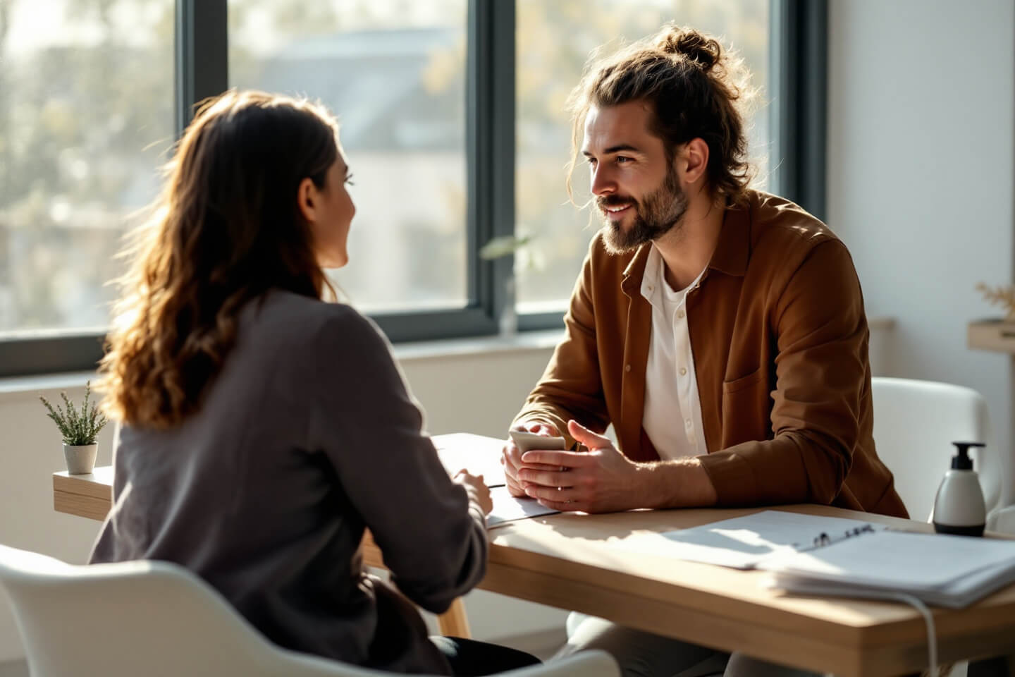 A professional therapist engaging with a patient in a bright, modern consultation room, symbolizing safe, regulated therapeutic sessions under the psilocybin program.