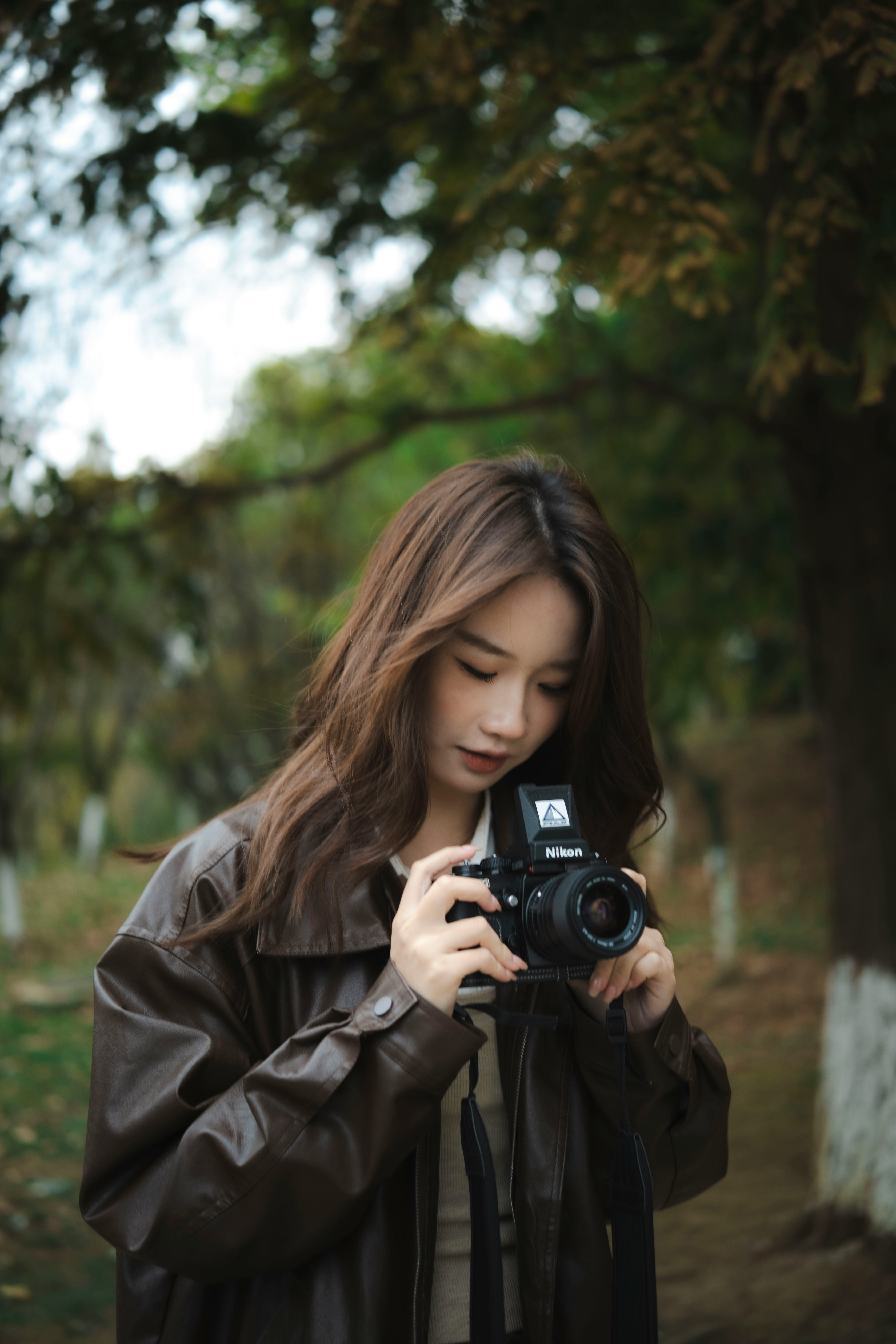 한국인처럼 생긴 아시안 여성이 필름카메라를 조작하는 모습