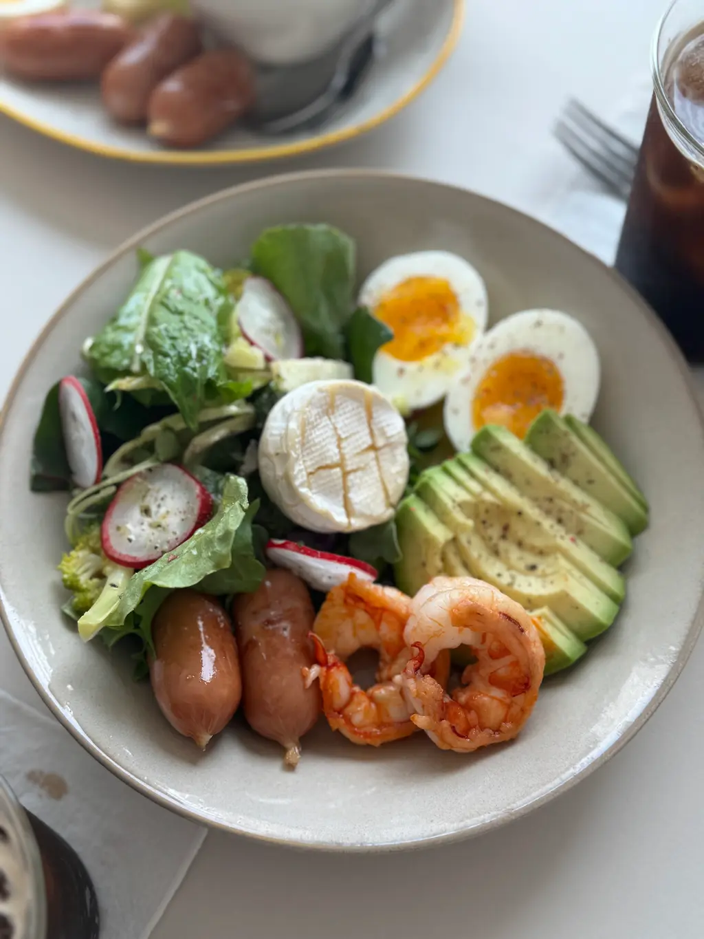 샐러드,계란, 소시지, 아보카도가 들어있는 브런치 접시