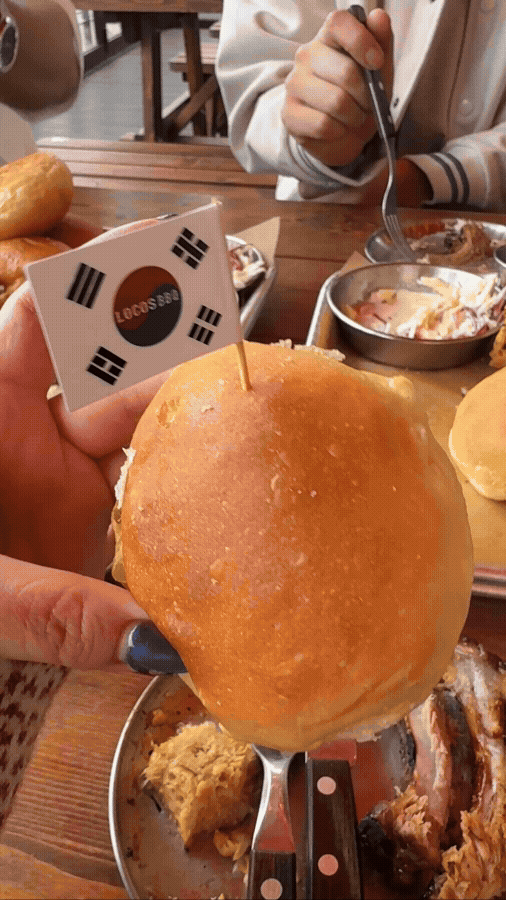 로코스바비큐 번 위에 고기 올리고 태극기 픽 꽂아 서빙되는 장면 GIF