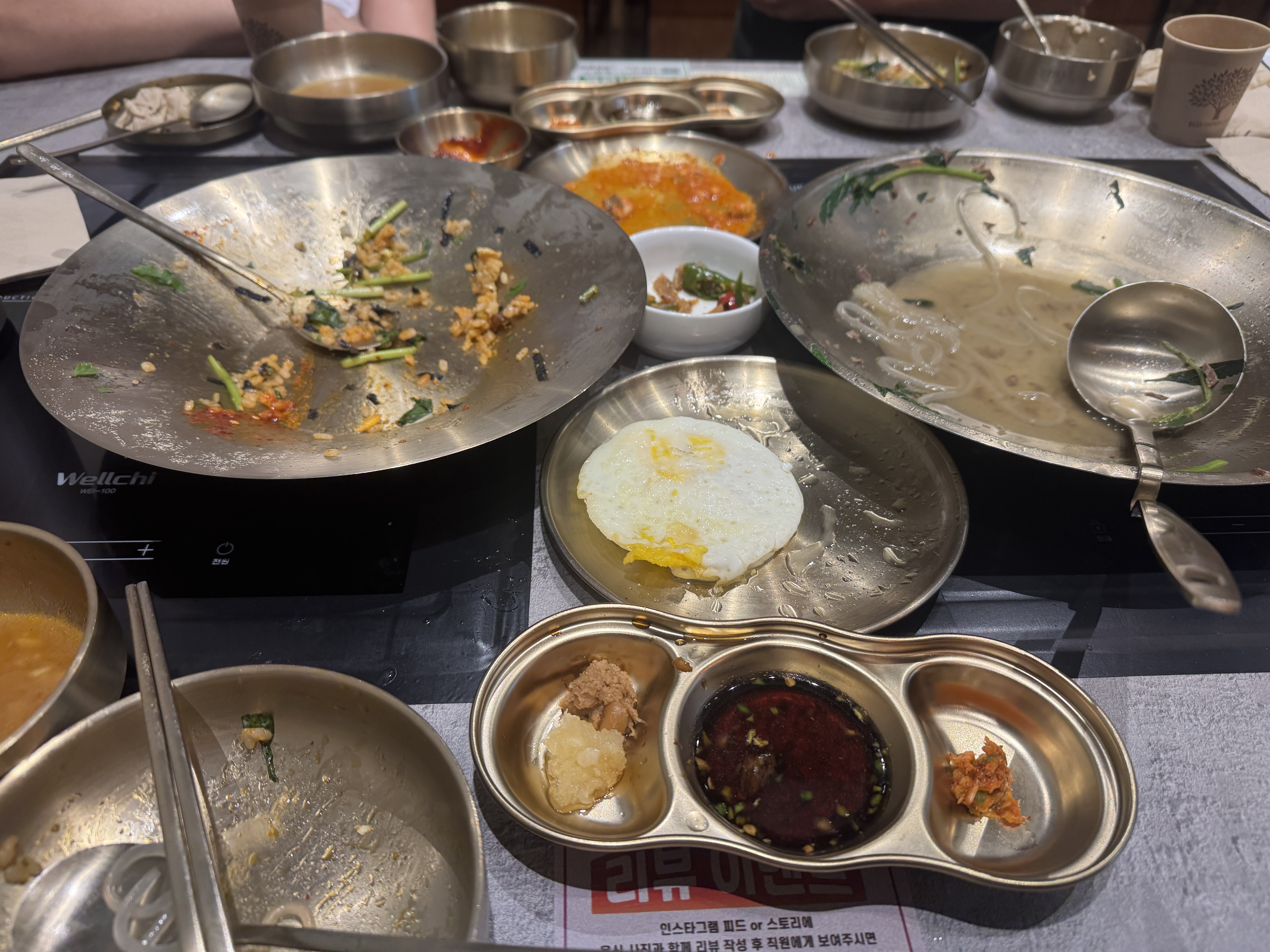 미금역 옥된장 식사 후 빈 접시와 남은 반찬이 놓인 테이블, 거의 비워진 전골과 비빔밥 그릇