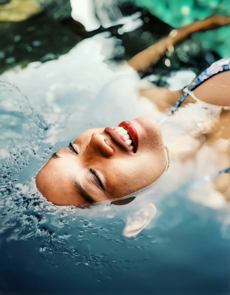 물 위에서 편안하게 웃으며 부유하는 여성의 회복 이미지