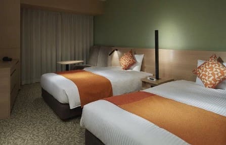 푹신해 보이는 침대 2개가 나란히 놓여 있는 객실