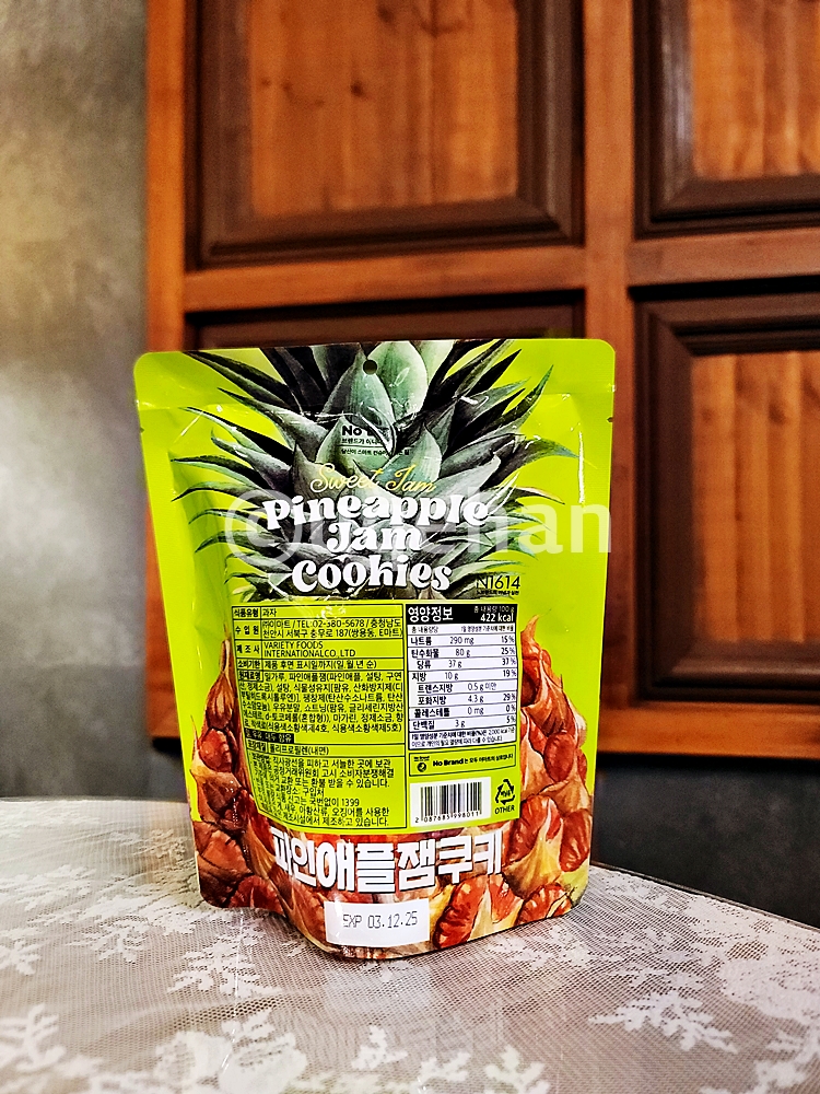 노브랜드 파인애플잼쿠키의 상세설명이 나와있는 부분이 정면을 향하게 두고 찍은 사진이다. 제품의 상세 및 영양정보가 쓰여있다.