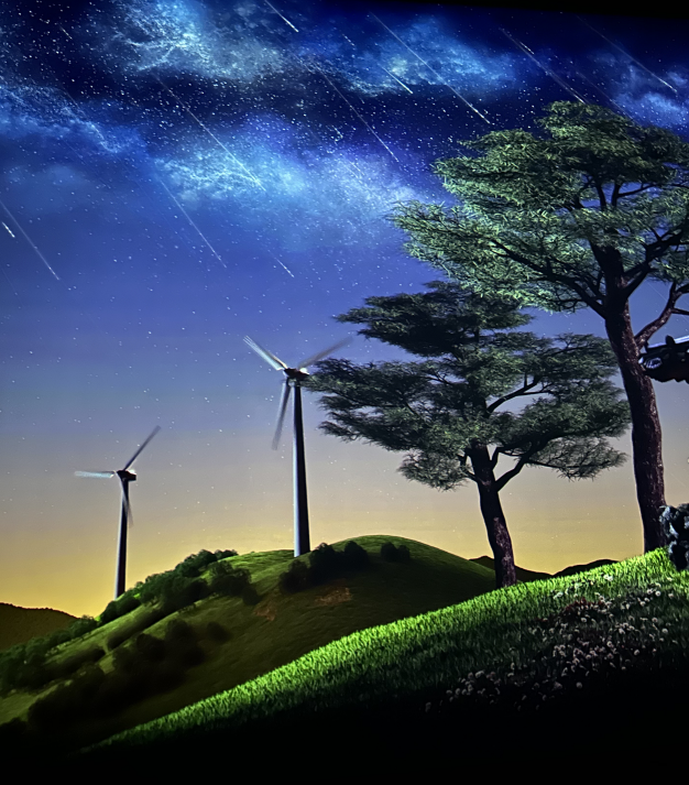 아르떼뮤지엄 강릉 NIGHT SKY 존&amp;#44; 언덕 위 풍력발전기와 별이 흐르는 밤하늘을 표현한 미디어아트 장면