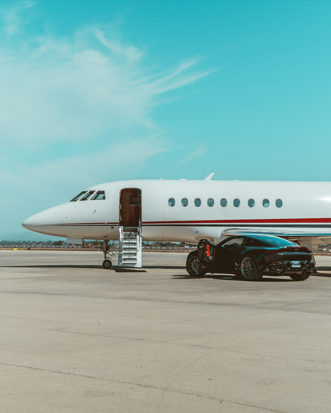 Seamless tarmac transfer between white Falcon jet and black Aston Martin