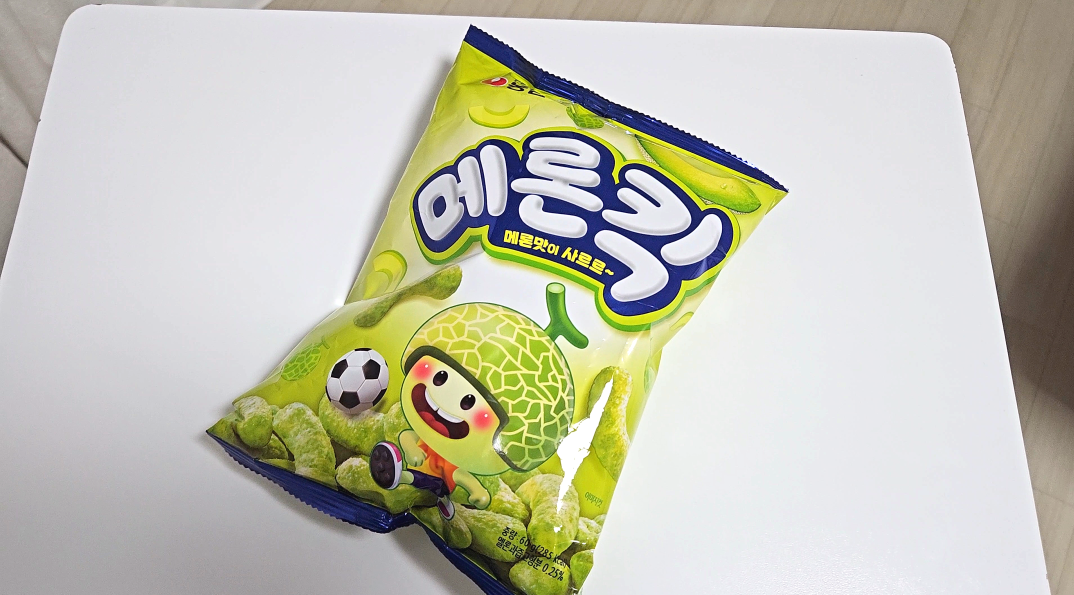 귀여운 캐릭터가 그려진 메론킥 과자 봉지 앞면 이미지