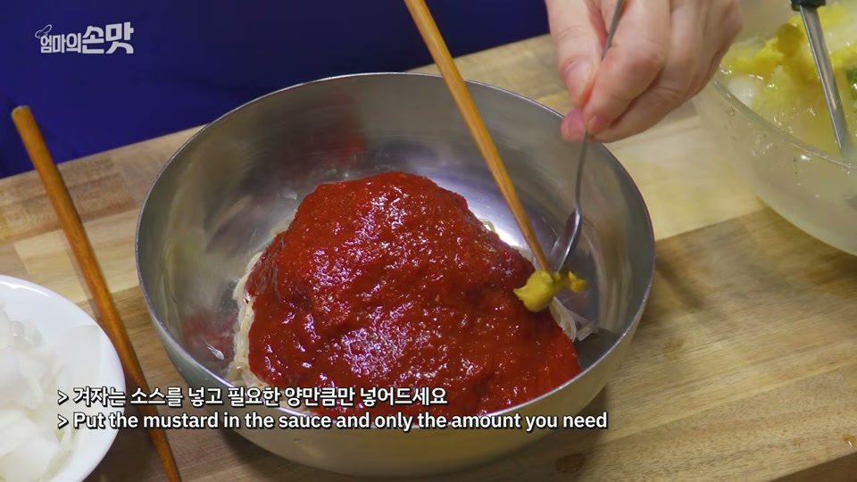그릇에 담긴 면에 양념장을 올리는 장면