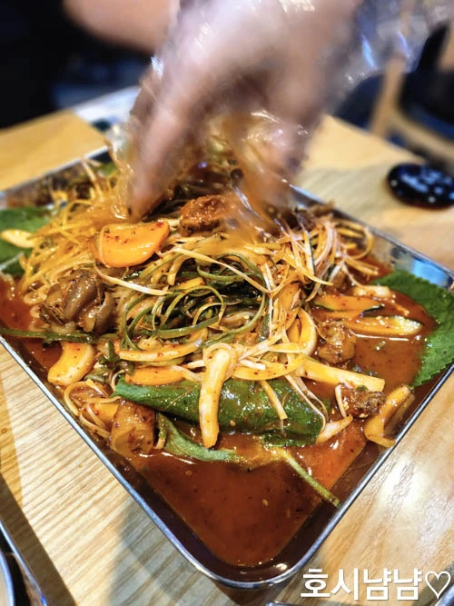 하남 누나홀닭 쫄뱅이 비비는 모습 – 양념이 잘 배어든 골뱅이와 야채, 쫄면을 비벼 먹는 장면