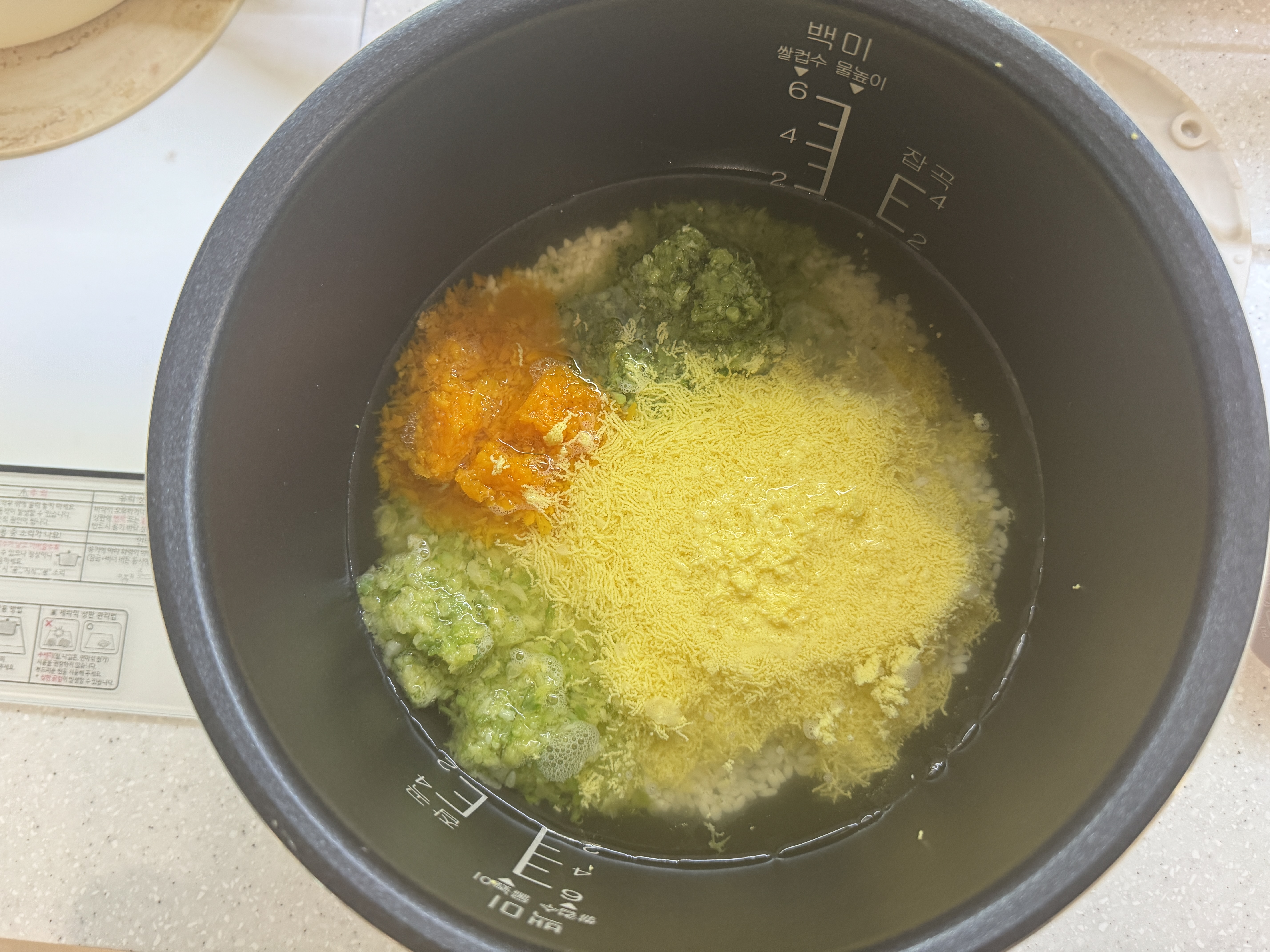 밥솥에 불린 쌀, 채수, 달걀, 단호박, 애호박, 브로콜리를 넣은 사진