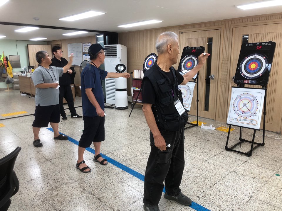 세명의 수강생이 한궁 과녁을 향해 핀을 던지고 있다