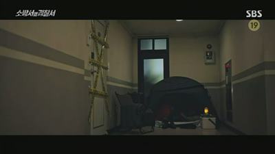 오피스텔 복도에서 텐트를 치고 자고 있는 사진입니다.