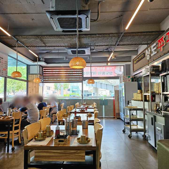 식당-내부가-아늑하고-왼쪽엔-사람들이-앉아서-먹고-있고-가운데-내부-자리는-비어있다-the-restaurants-seems-cozy-and-people-are-eating-on-the-left-and-the-middle-seats-are-empty