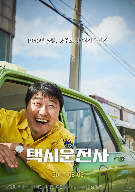 영화 택시 운전사 포스터. 주인공역인 김만섭(배우 송강호)가 택시 밖으로 고개를 내밀고 환히 웃고 있다.