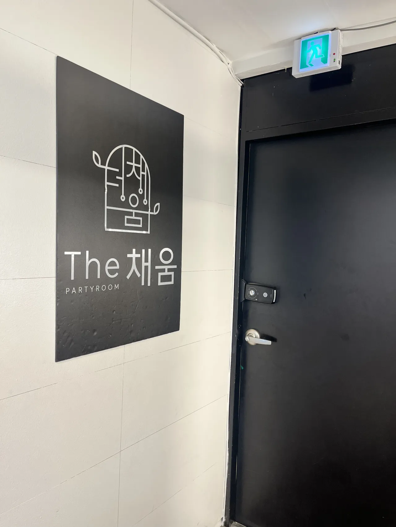 오른쪽-검정색-입구-문-왼쪽은-하얀벽-위에-더채움-검정색-포스터