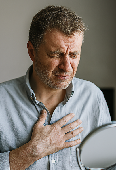 중년 남성이 스트레스로 인해 가슴을 움켜쥐며 고통스러운 표정을 짓고 있는 모습