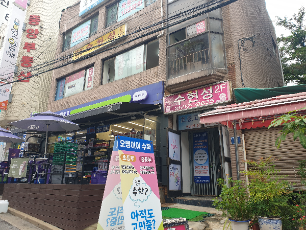 낡은 건물에 낡은 간판. 2층에 수현성이 있다.