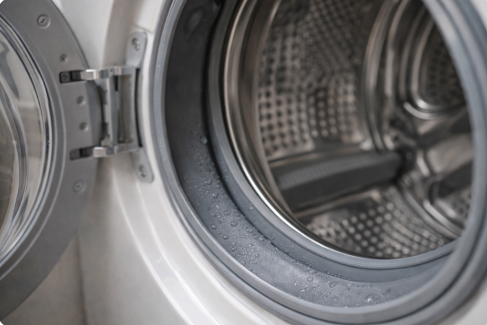 드럼 세탁기 문을 연 상태에서 고무 패킹과 내부 통에 물방울이 맺혀 있는 모습