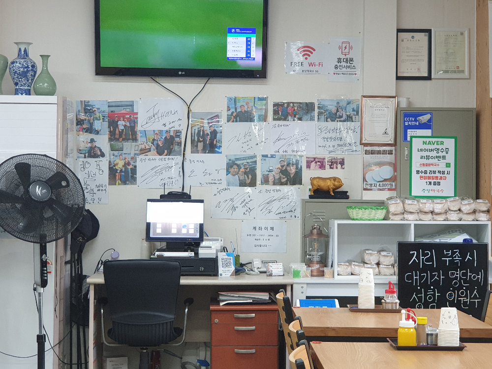 한 쪽 벽면 TV 모니터 아래 유명인들의 싸인이 붙어있다.