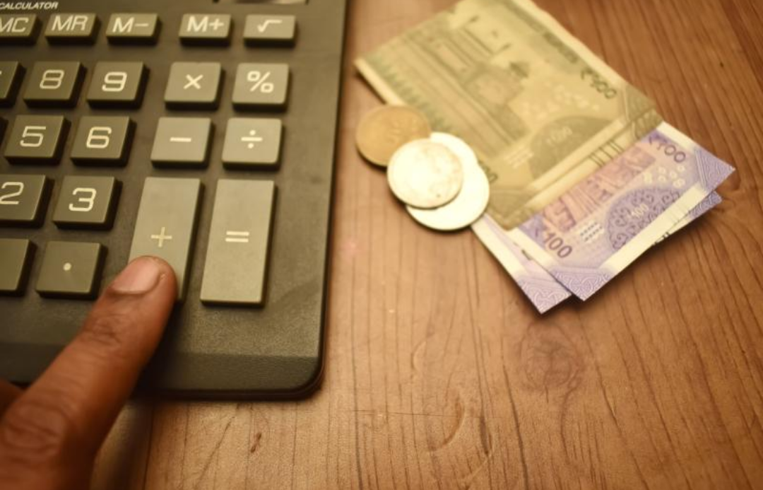 계산기와 지폐와 동전들이 놓여 있다.