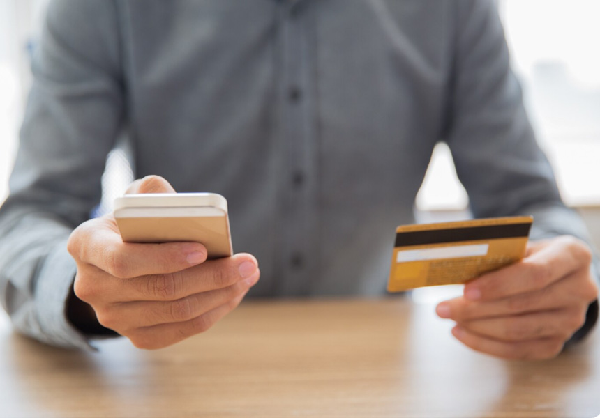 신용카드와 스마트폰으로 OTT 할인 혜택을 확인하는 장면