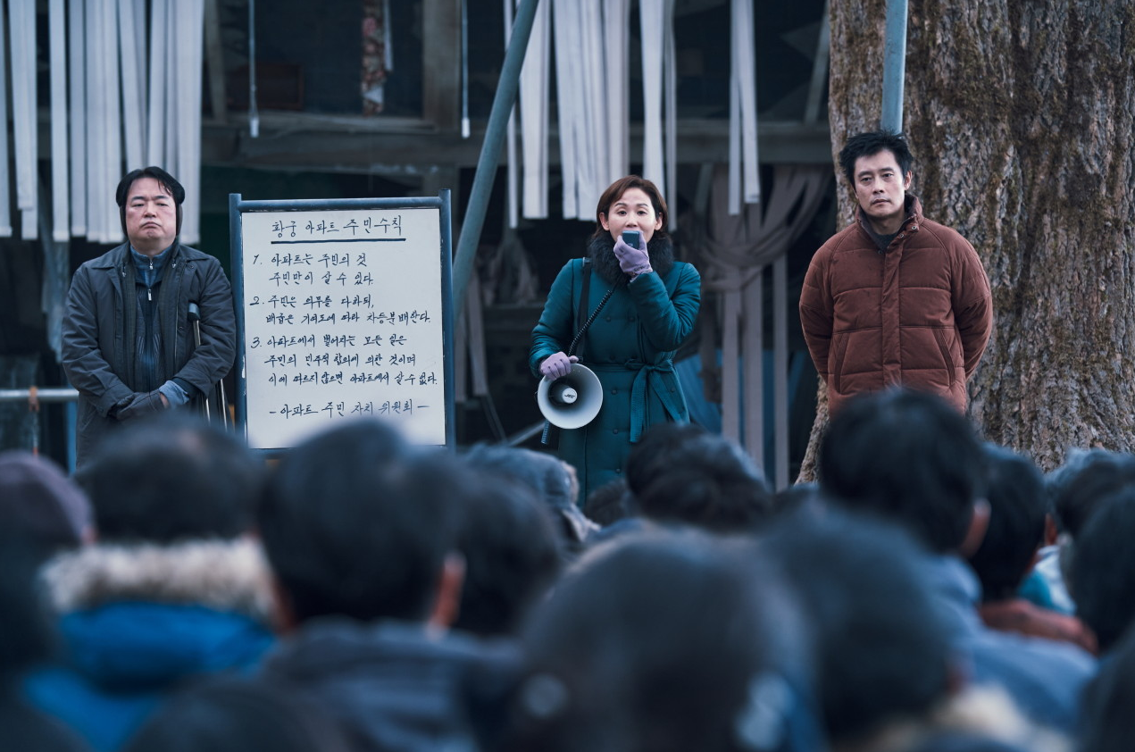 황궁 아파트 주민수칙이 적힌 칠판 앞에서 주민 대표가 확성기로 규칙을 낭독하고 영탁이 옆에 서 있는 장면