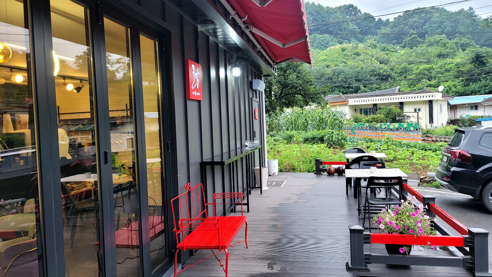 시골 마을 작은 카페 외관. 텃밭과 산이 보이는 데크에서 첫 손님을 기다리던 따뜻한 공간의 모습.