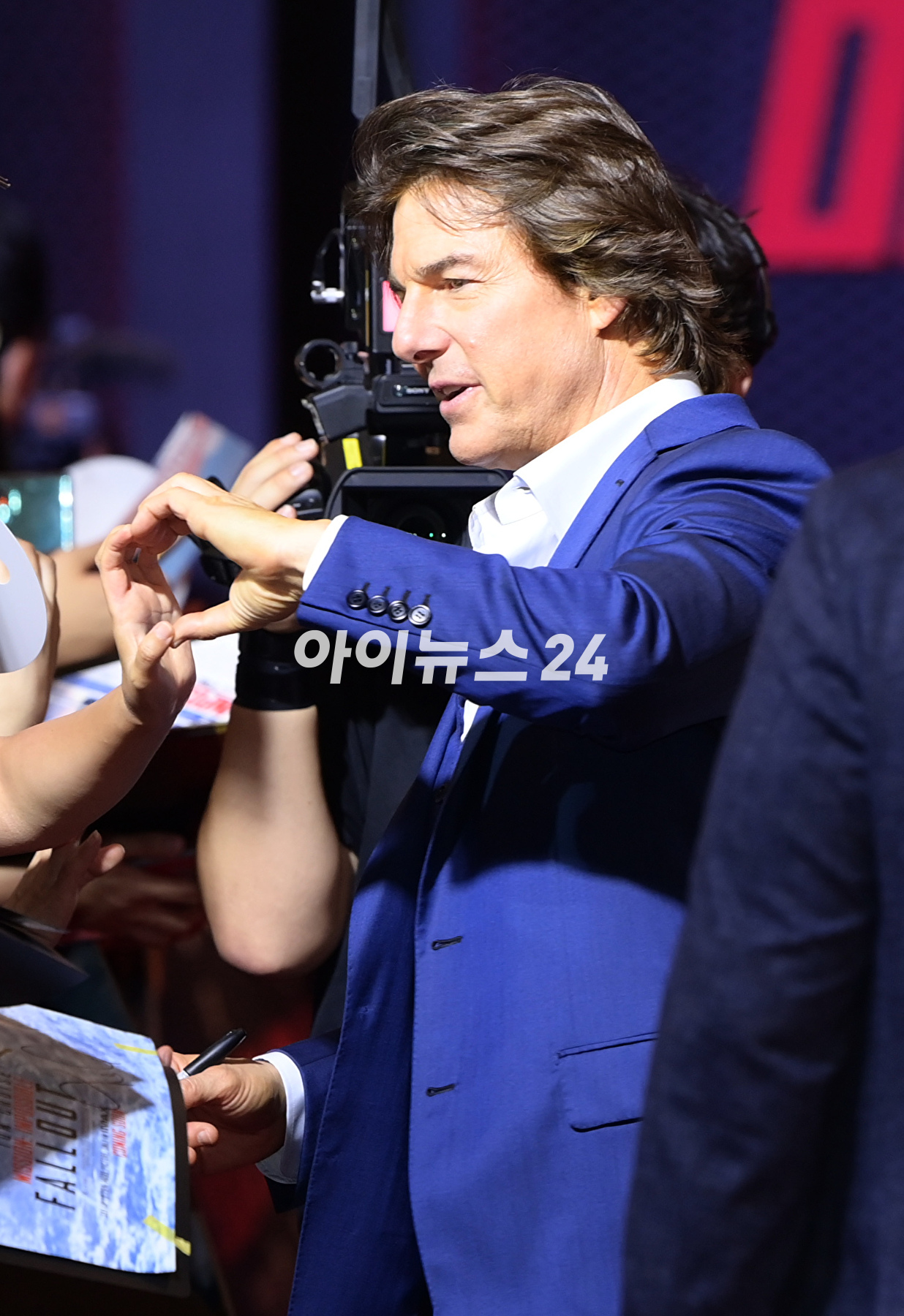 배우 톰 크루즈가 29일 오후 서울 송파구 롯데월드타워에서 진행된 영화 '미션 임파서블: 데드 레코닝 파트 원'(감독 크리스토퍼 맥쿼리) 내한 레드카펫 행사에 참석해 한 팬에게 자신의 얼굴이 새겨진 부채를 받고 기뻐하고 있다. [사진=정소희 기자]