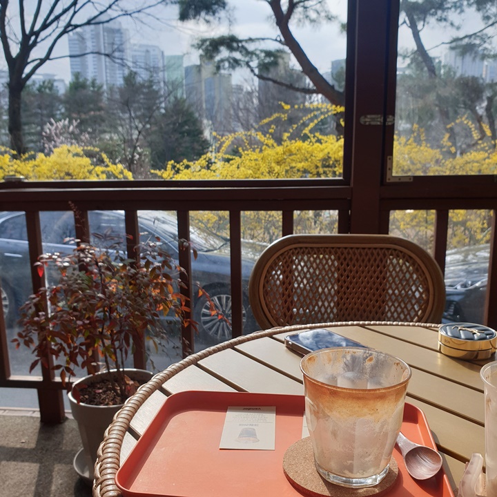 벤더커피-야외테라스는-햇빛이-잘들고-뒤엔-개나리가-보인다