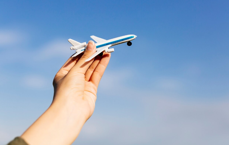 비행기 장난감을 잡고 하늘에 날리고있다