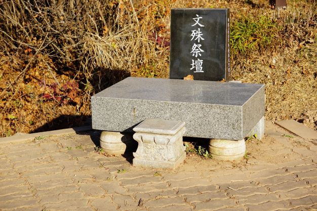 문수제단, 흰글씨, 한자, 비석은 검은 돌, 받침대는 사각 회색 돌,