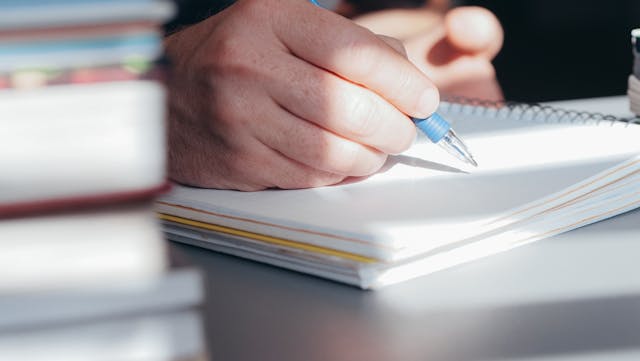 습관을 기록하는 손과 노트 이미지