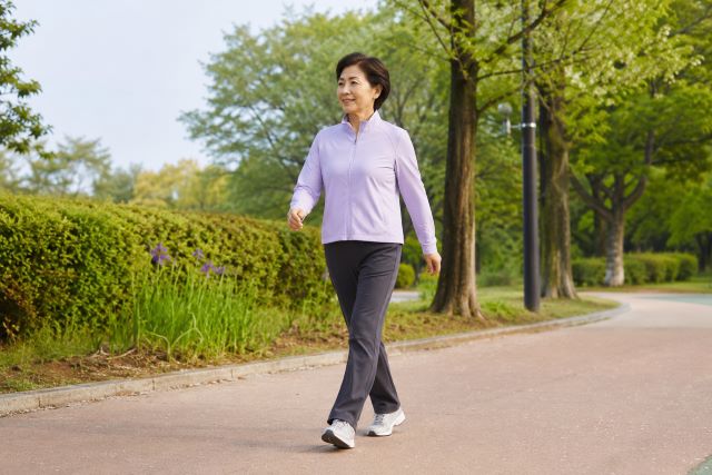 공원 산책로에서 바른 자세로 걷는 60대 여성
