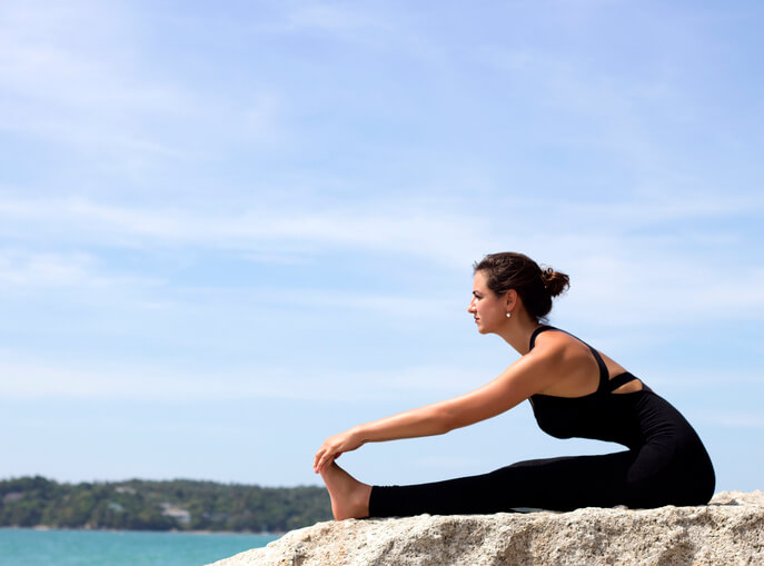 앉아서_앞으로_숙이는_자세를_하는_여성의_모습